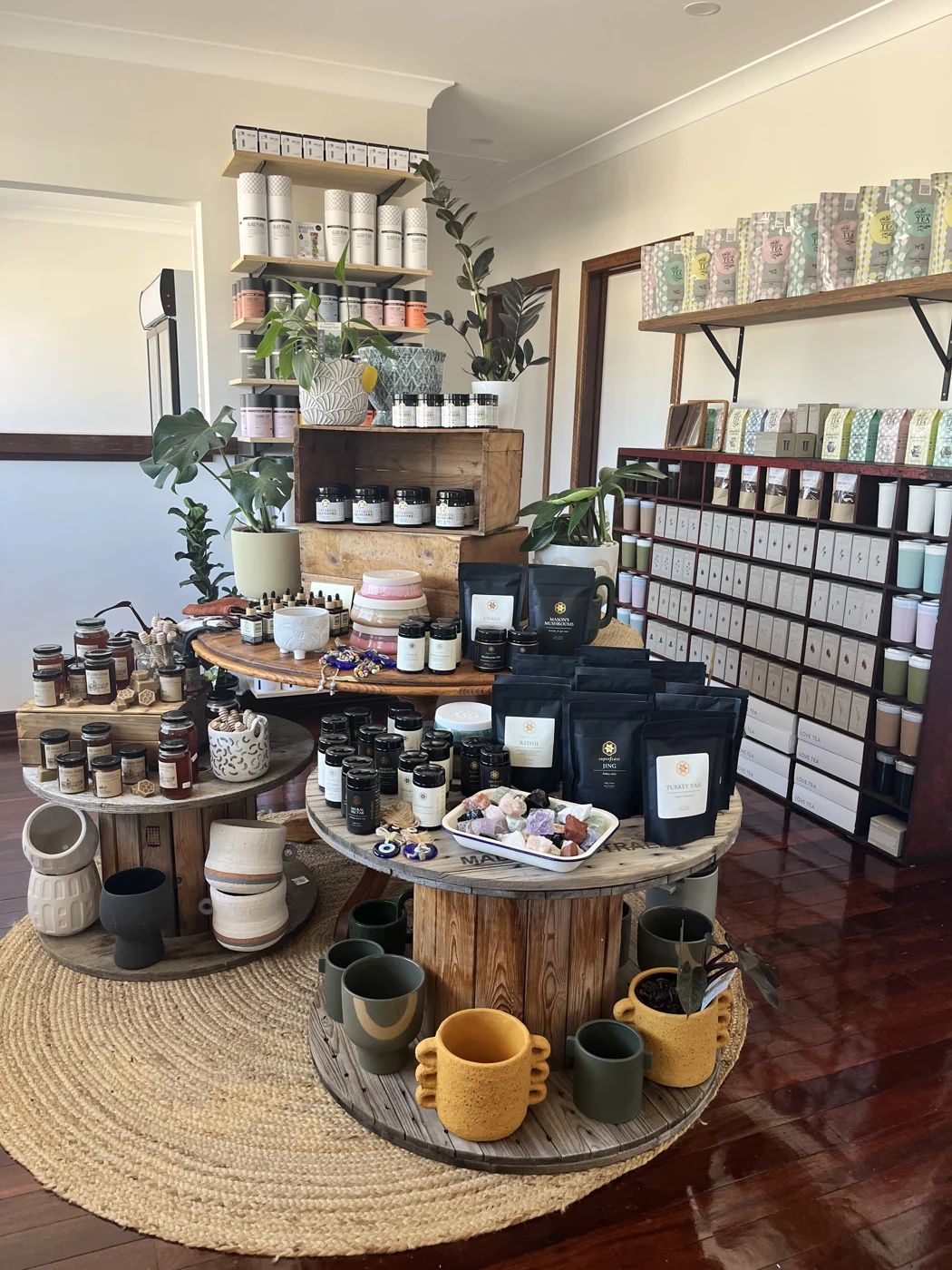 Tea boxes, mushroom products, pottery and plants on the shop’s timber displays